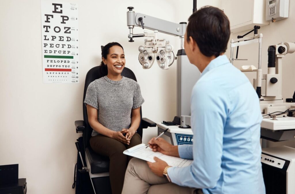 Patient smiling during an eye exam consultation with an optometrist.