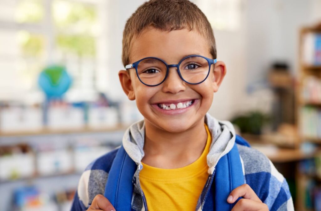 A child wearing myopia control glasses smiles brightly.