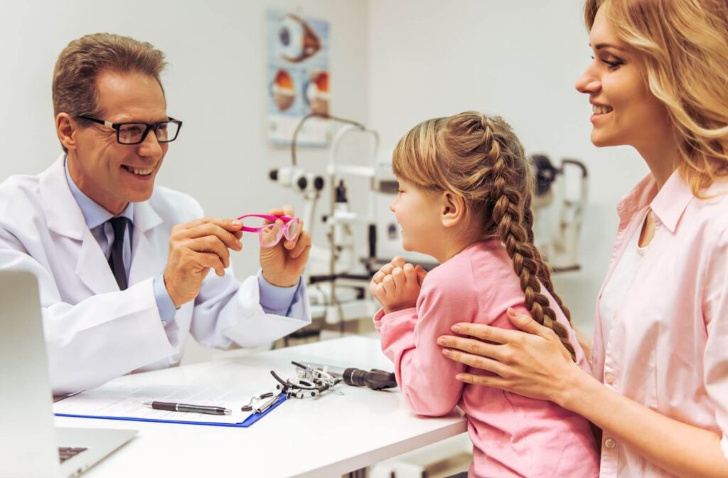 A young patient and their parent learn about myopia eyeglasses from their eye doctor.